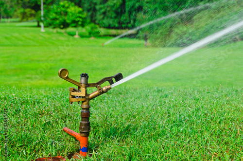 A metal automatic water sprinkler in the field