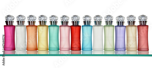 Glass bottles of perfume in a row on glass shelf
