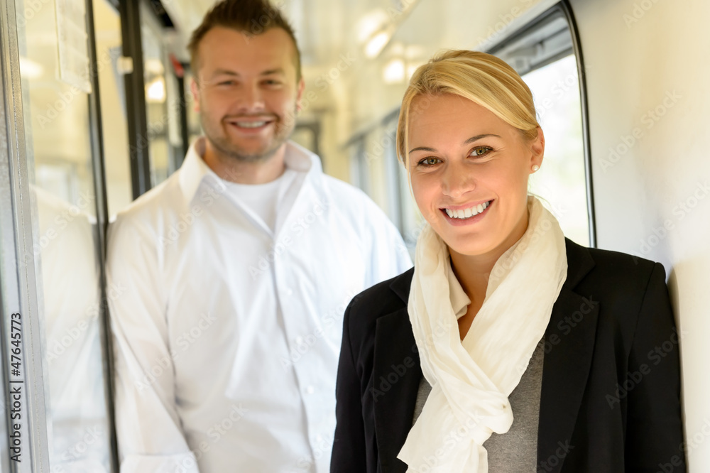 Woman and man smiling standing in train