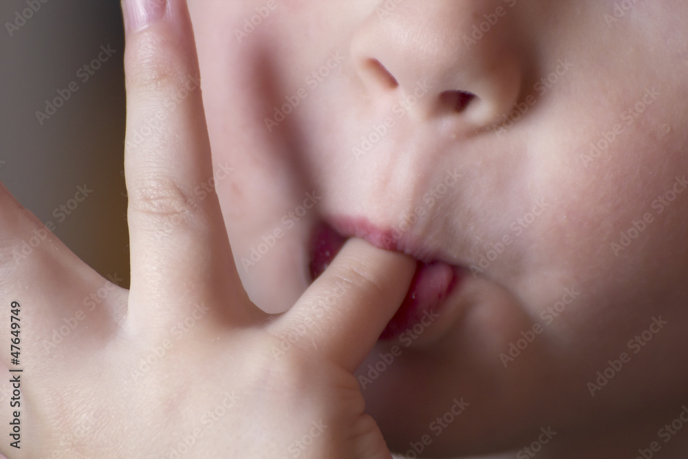 Small child face licking fingers Small child face licking fingers