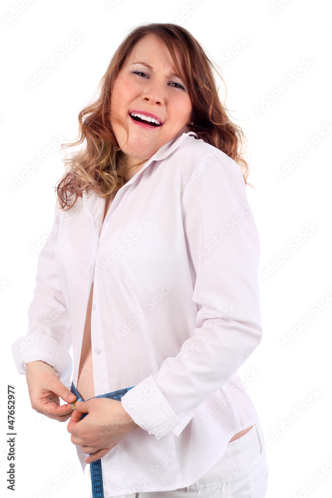 Pregnant woman in white tries to tighten centimeter tape Pregnant woman in white tries to tighten centimeter tape