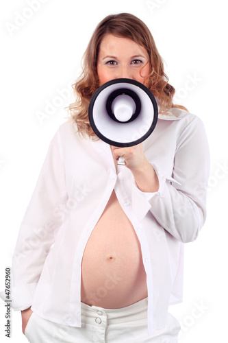Pregnant woman in white speaks into megaphone isolated on white photo