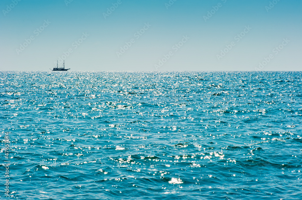 Blue sea with a ship on the horizon