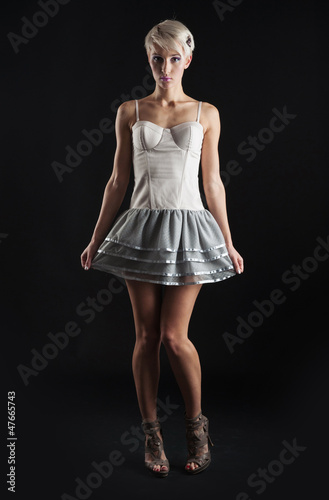 Young girl portrait with short dress isolated against black 