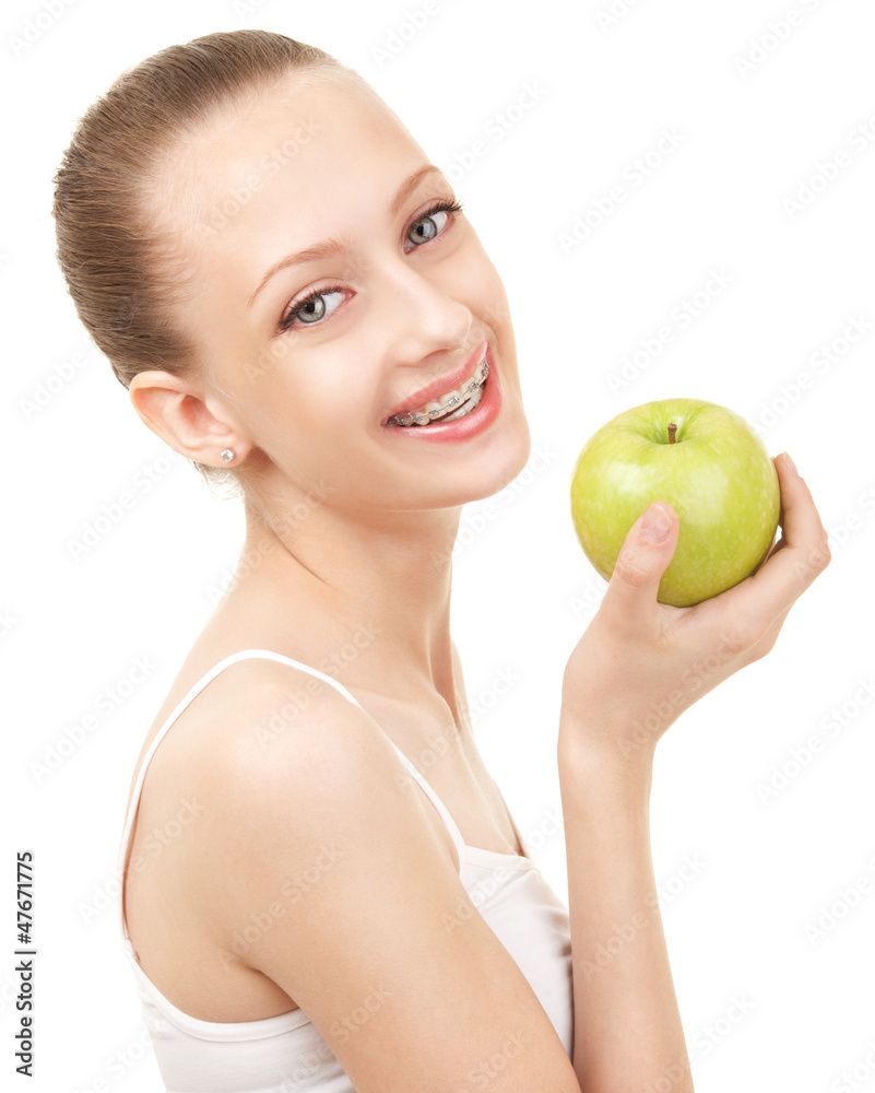 Cute girl in braces with green apple on white background Cute girl in braces with green apple on white background