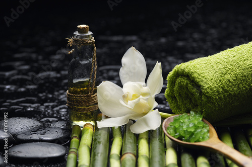 Green salt in spoon with massage oil and thin bamboo