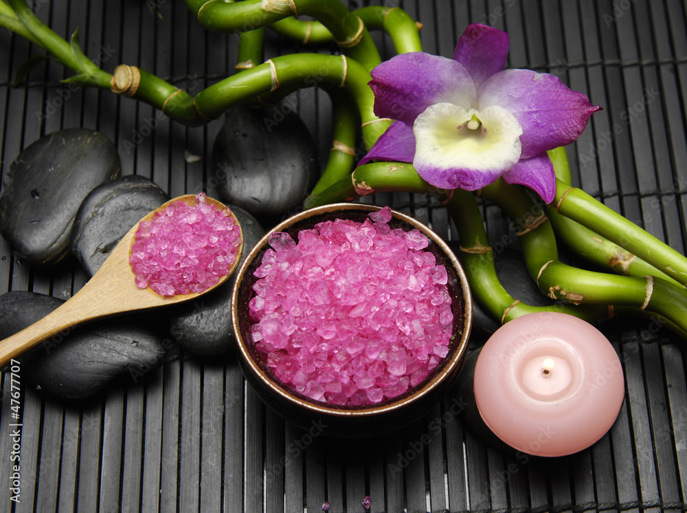 Pink orchid, candle with zen stone and sea salt in spoon on mat Pink orchid, candle with zen stone and sea salt in spoon on mat