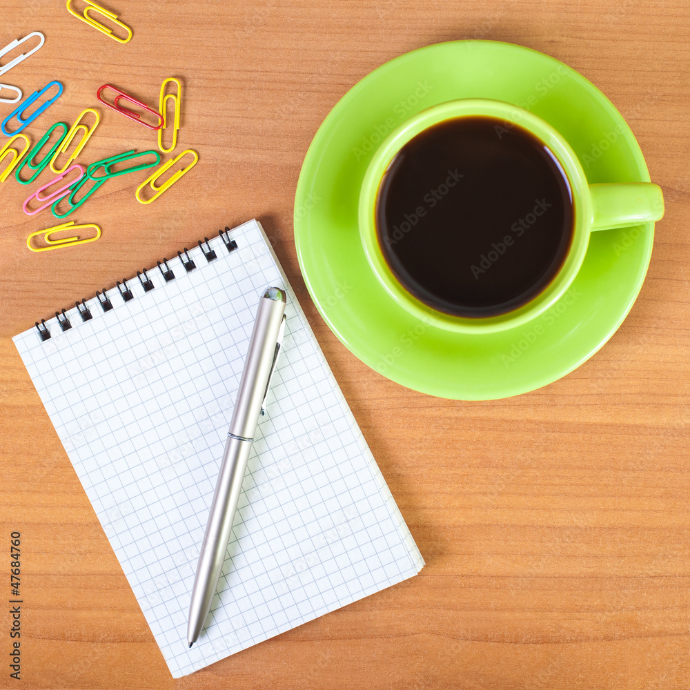 Coffee cup, notebook and pen on a desk Coffee cup, notebook and pen on a desk