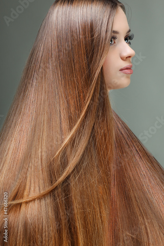 Portrait of beautiful girl with long hairs, on a grey 