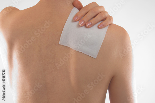 女性の肩に湿布薬 photo
