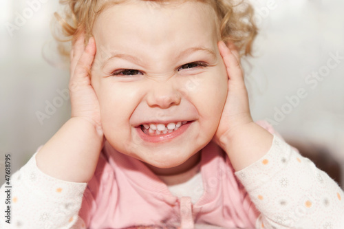 Excited baby girl leaning on her hands