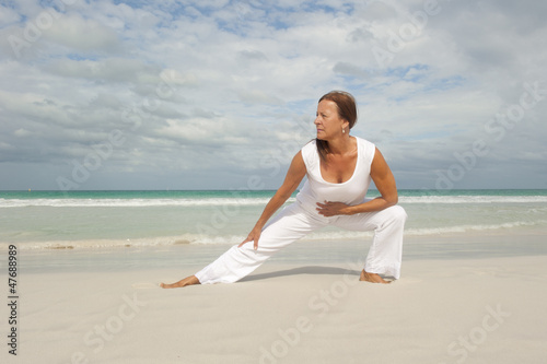 Fit mature woman exercising ocean isolated