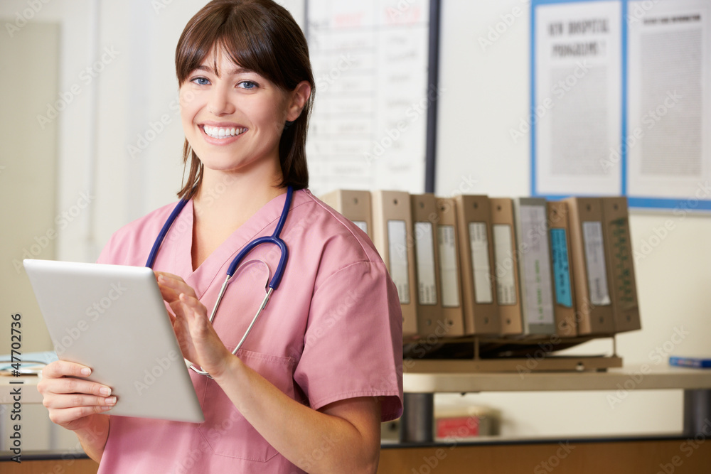 Nurse Using Digital Tablet At Nurses Station Nurse Using Digital Tablet At Nurses Station