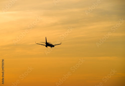 Jetliner flying against red sunset sky © Olaf Speier