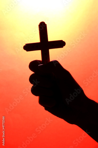 man hand with crucifix, on red background.
