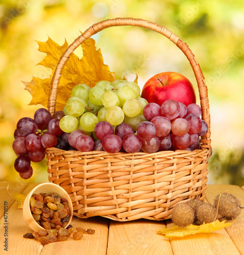 Grape in basket with nuts on wooden table