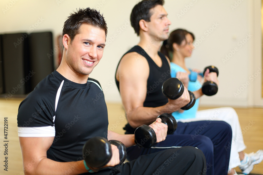Group of three people training with gymnastic balls and dumbbell Group of three people training with gymnastic balls and dumbbell