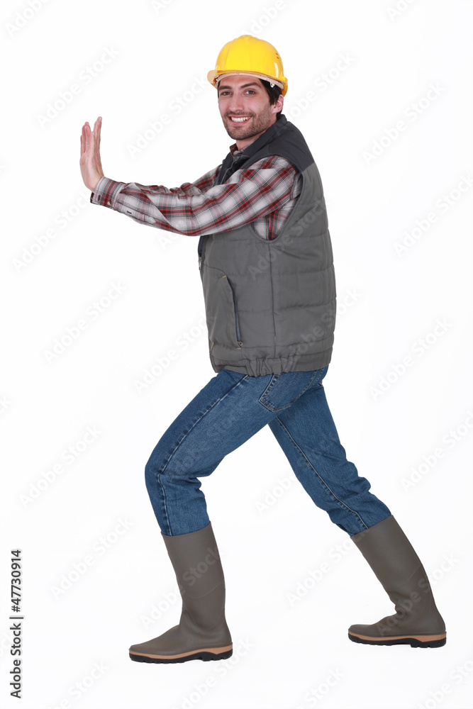 A construction worker pushing something invisible. A construction worker pushing something invisible.