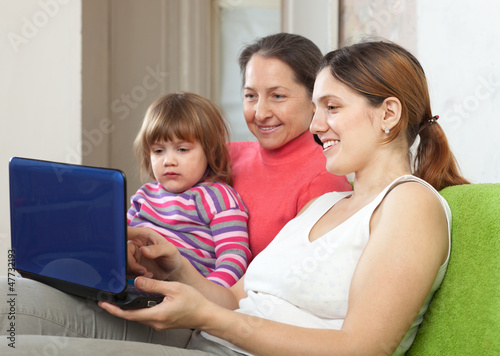 Family of three generations with laptop