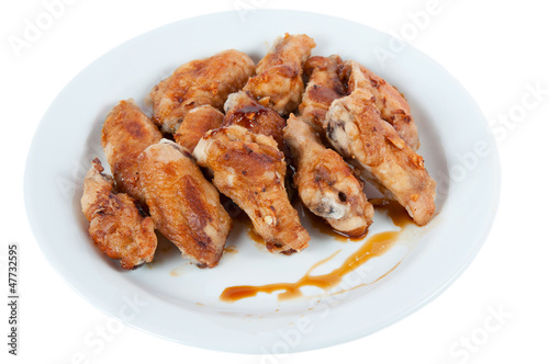 Plate with roasted chicken wings, isolated on white