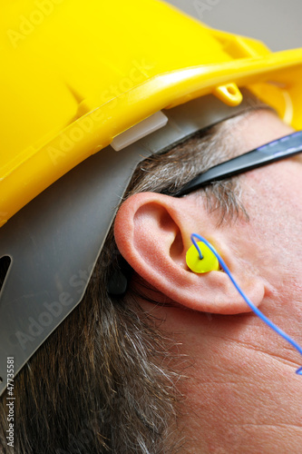 yellow earplug into the ear close up