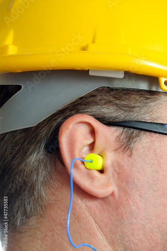 Foto yellow earplug into the ear