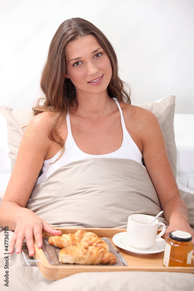 Woman eating breakfast in bed