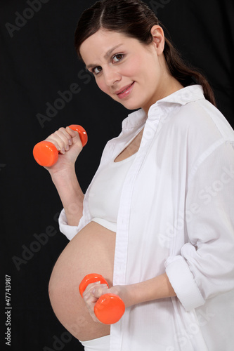 Pregnant woman using hand weights