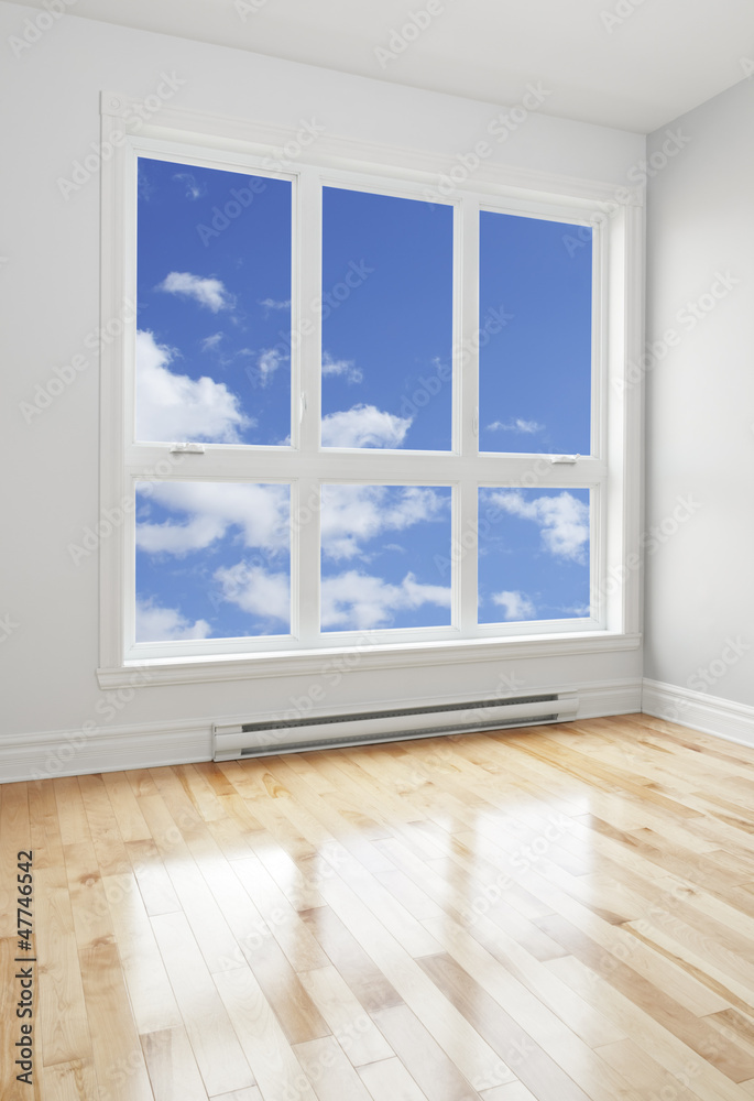 Fototapeta premium Empty room and blue sky seen through the window
