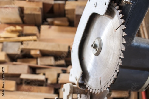 Compound Mitre Saw cutting planks wooden background