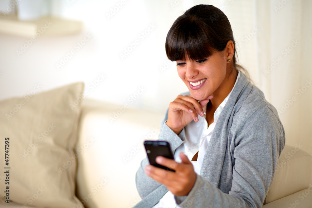Charming young woman reading message on cellphone Charming young woman reading message on cellphone