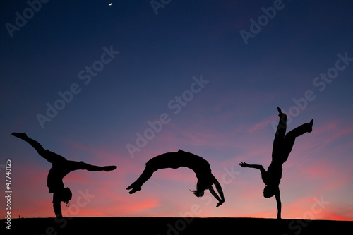 group of gymnasts tumbling in sunset