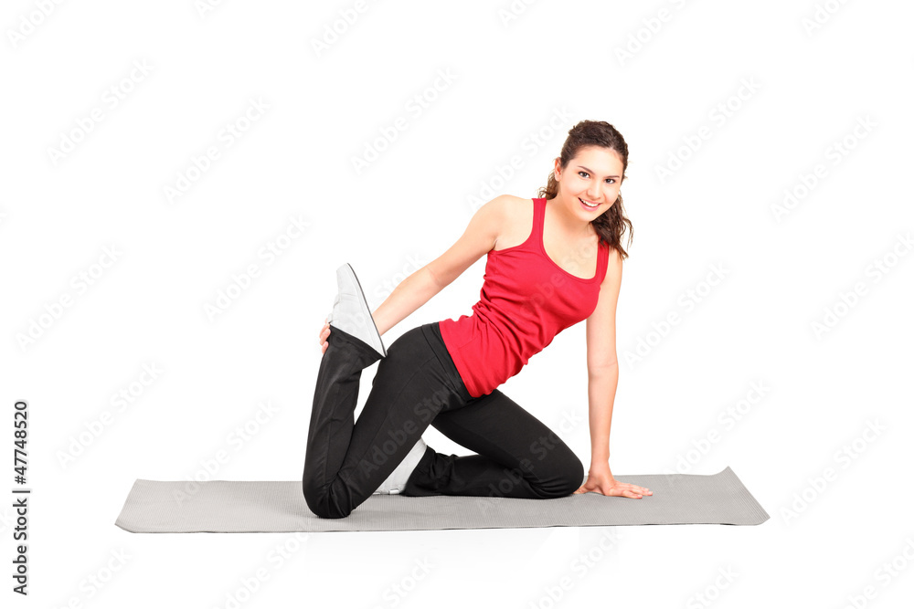 A young female athlete exercising on a mat