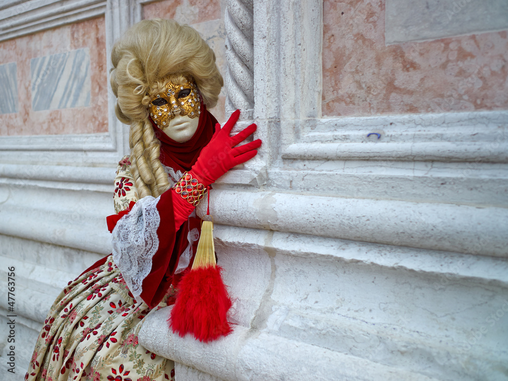 Person in Venetian costume attends Carnival of Venice.