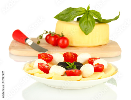 sliced mozzarella cheese with vegetables in the plate isolated