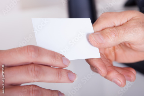 Man handing a woman a business card