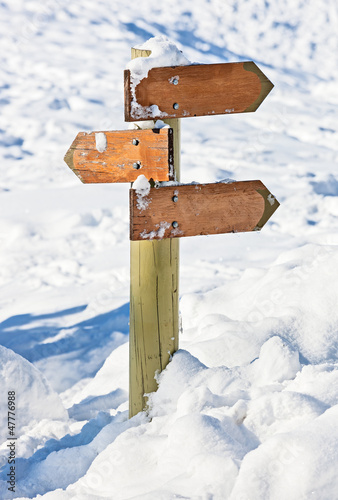 Old snow covered wooden signpost (index arrowhead)