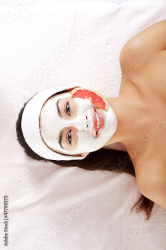 Attractive young woman with fruit mask on a face