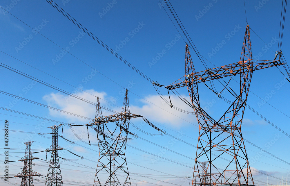 four power high voltage tower over blue sky