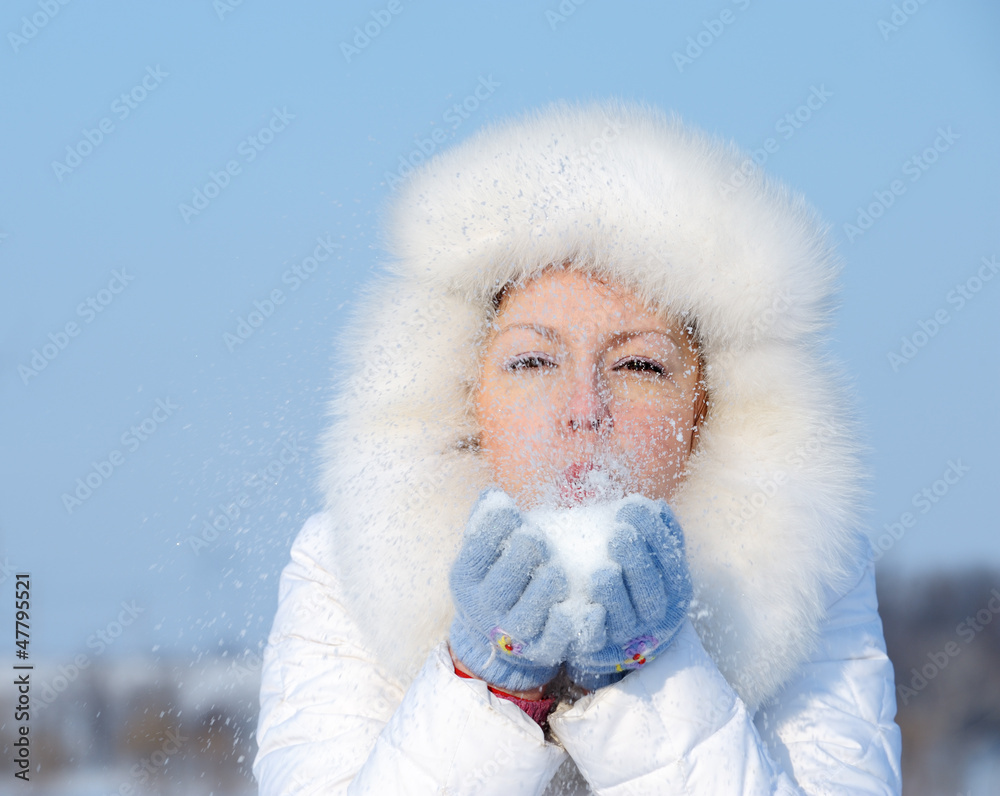 Girl blows off snowflakes from the hand Girl blows off snowflakes from the hand