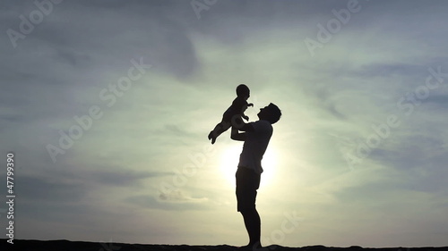 father playing with his child on the sea coast