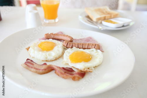 Breakfast with bacon , fried egg and orange juice