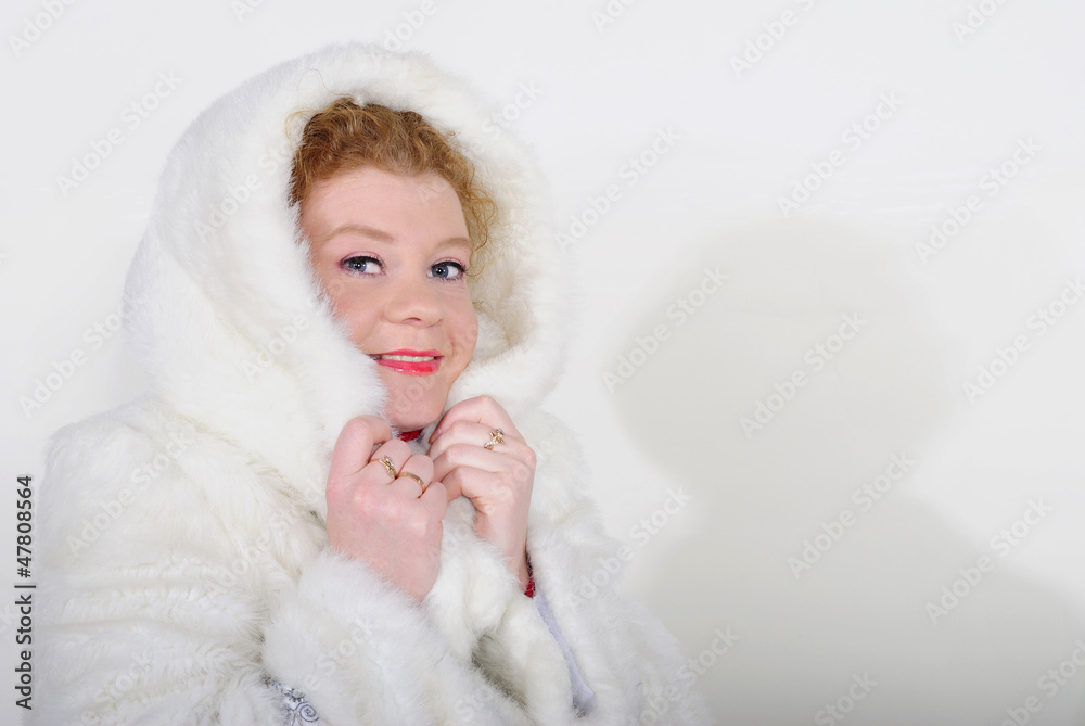 The young beautiful girl in a fur cap on a white background The young beautiful girl in a fur cap on a white background