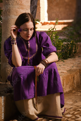 Brunette girl in a medieval suit in a Agia Napa Medieval Monaste photo