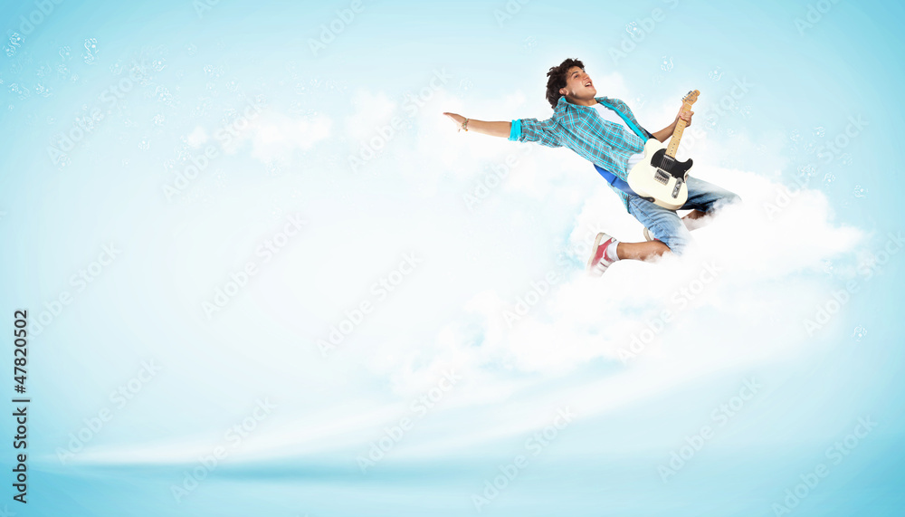 young man playing on electro guitar and jumping young man playing on electro guitar and jumping