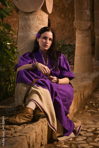 Brunette girl in a medieval suit in a Agia Napa Medieval Monaste photo