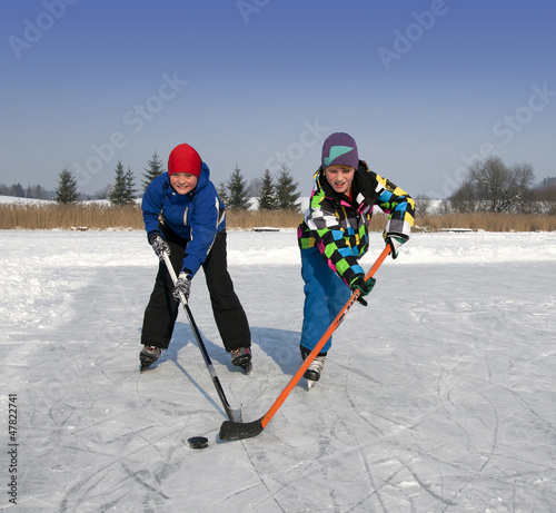 Photography Zwei Jungen spielen Eishockey auf zugefrorenem See