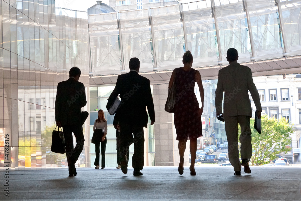 Employees going against the office. Panorama. Silhouettes. Employees going against the office. Panorama. Silhouettes.