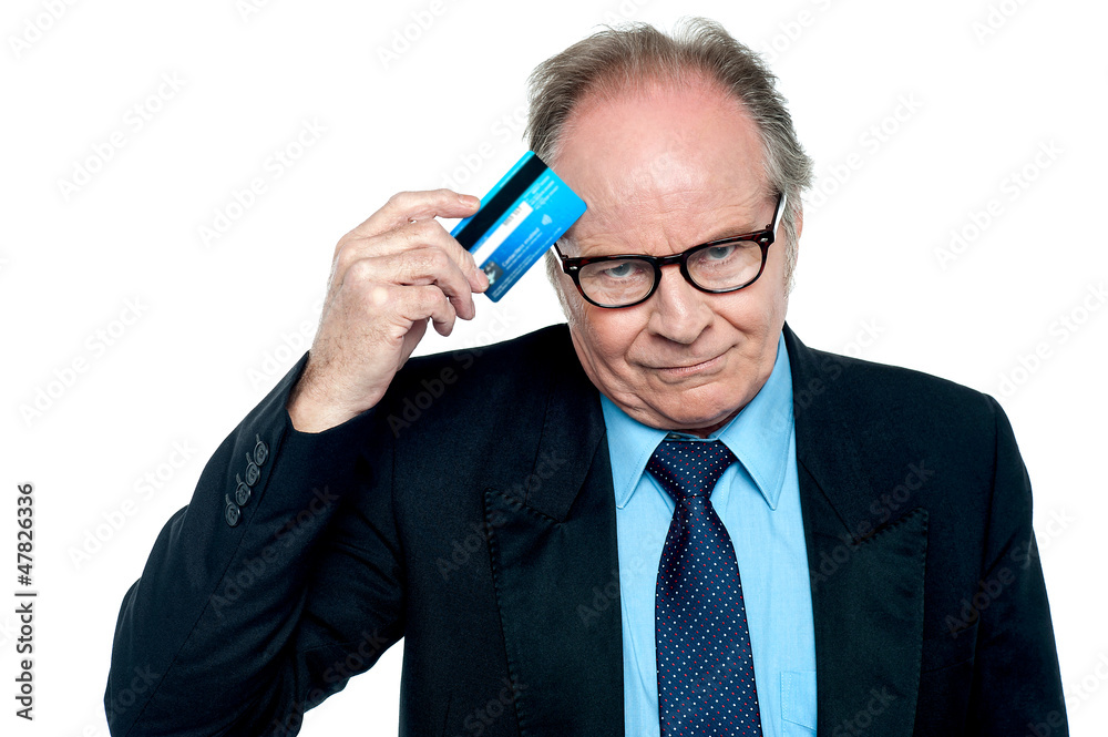 Businessman scratching his forehead with plastic card