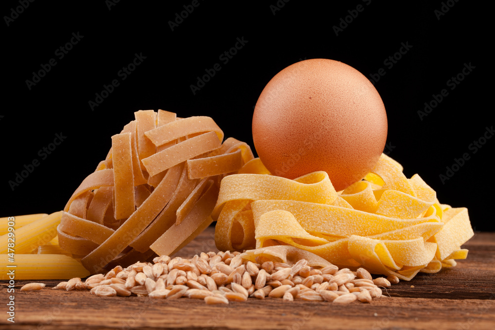 egg and pasta assortment on black background